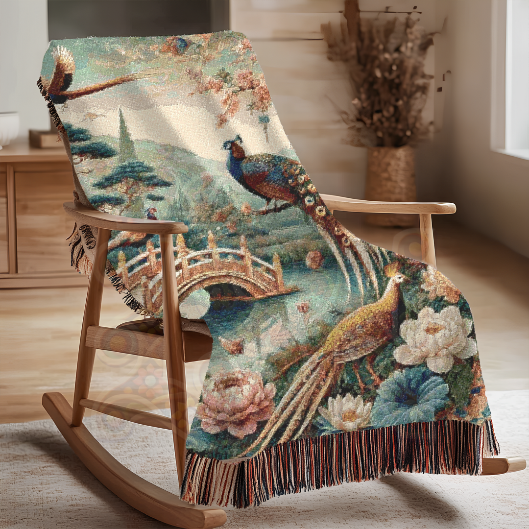 Japanese garden-inspired woven blanket shown draped on a rocker. Features majestic peacocks, blooming peonies, and an arched bridge. Made of 100% cotton—perfect for peaceful, artful home decor.